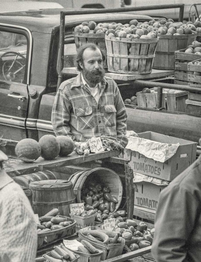 man selling vegetables at farmers market