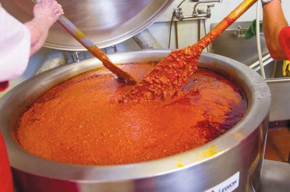 stirring a pot of fresh tomato sauce